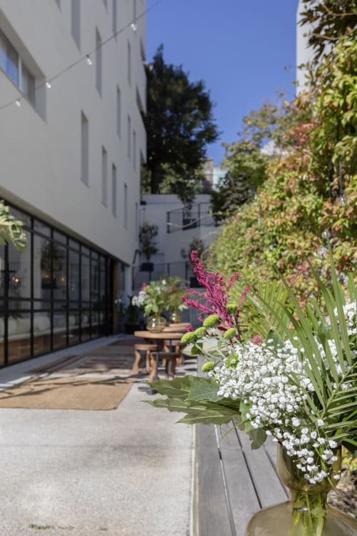 Contemporary hotel courtyard in Porto with flowering plants, seating area, and modern white building facade