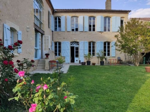 Jardin fleuri du Rêve d’Alice avec vue sur la façade de la maison d’hôtes.
