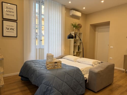 Camera da letto Encanto a Napoli con vista sulla città, letto moderno, pavimenti in legno e decorazioni murali ispiratrici