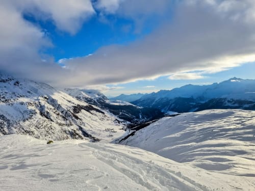 Snow-covered alpine landscape with mountain valleys near Bellano, Italy, showcasing winter scenery with blue sky
