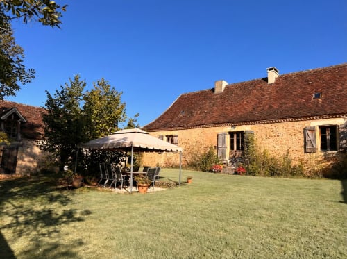 Gîte en pierre rustique avec pelouse soignée et terrasse ombragée à Le Lapin sur le Toit, Rouffignac, France