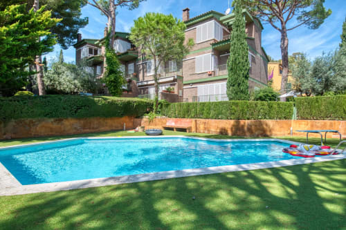 Luxury swimming pool at Finques Garcia Enrich hotel in Palafrugell with terracotta walls, manicured gardens, and