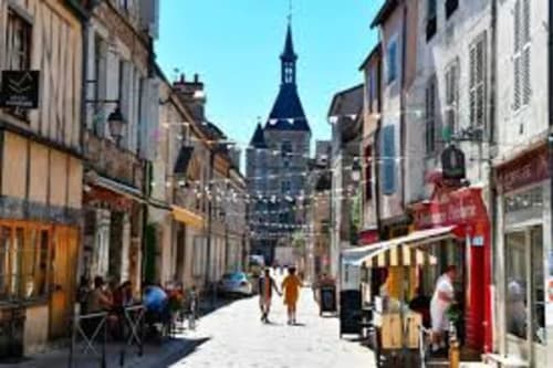 Charming cobblestone street in Sermizelles, France with historic architecture and church spire, near Les Gîtes de l'Impériale