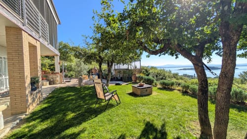 Villa sul lago con giardino maturo, prato verde, fuoco e viste sul waterfront in Italia