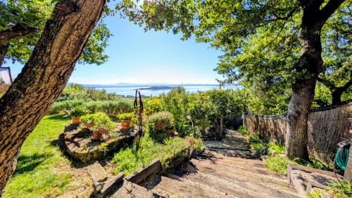 Giardino con vista sul lago, alberi secalari, spazi verdi rigogliosi e vedute acquatiche presso Villa Italia Management in Italia