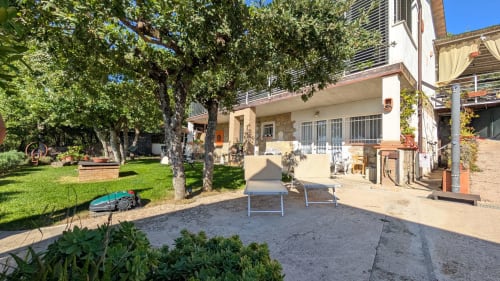 Villa Italia con giardino, vista lago, alberi ombrosi, patio e casa in mattoni nella campagna italiana