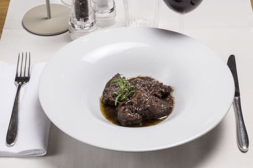 Fine dining plate at Palazzo Belvedere hotel in Chianciano Terme featuring braised beef with rosemary garnish and jus