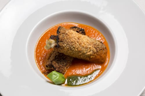 Gourmet plated dish at Palazzo Belvedere in Chianciano Terme with seared meat on orange sauce and basil