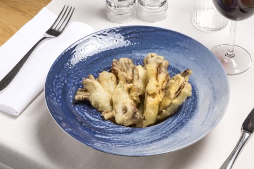Elegant plated pasta dish at Palazzo Belvedere, Chianciano Terme, with blue ceramic plate and fine dining setup