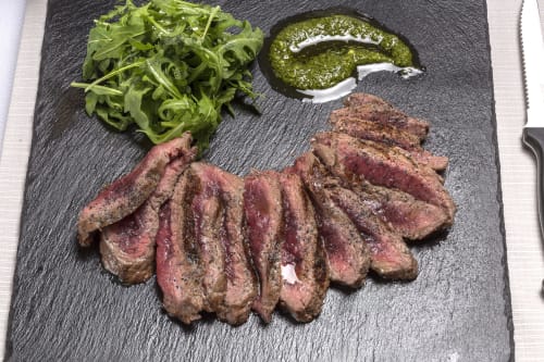 Sliced medium-rare beef steak with arugula and pesto sauce at Palazzo Belvedere, Chianciano Terme