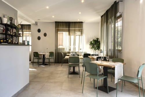 Elegant dining room at Palazzo Belvedere hotel in Chianciano Terme with green chairs, wooden tables, and natural light from