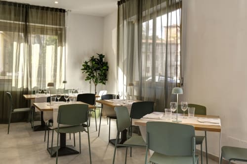 Modern restaurant dining area at Palazzo Belvedere hotel in Chianciano Terme with green chairs, wooden tables, and natural