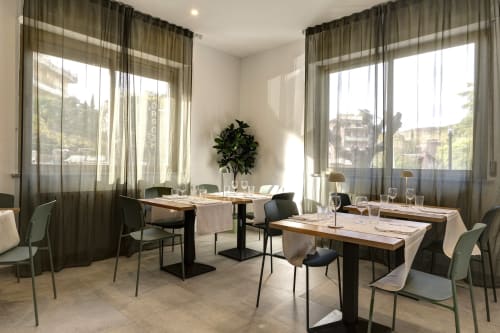 Elegant dining room at Palazzo Belvedere in Chianciano Terme with large windows, natural light, and modern furnishings