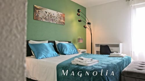Chambre Magnolia de la Villa Pré d'Oro - lit double avec couvre-lit bleu, coussins turquoise et mur vert