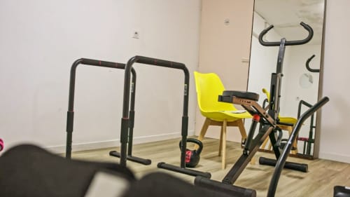 Salle de sport de la Villa Pré d'Oro avec équipements fitness - barres, kettlebell et vélo