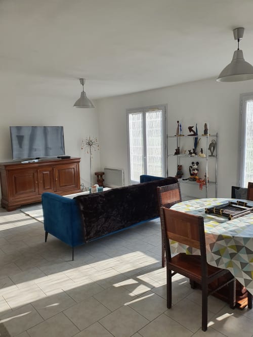 Appartement spacieux et lumineux à l'Hôtel Cheverny avec canapé bleu, mobilier en bois, salle à manger et vue sur le jardin