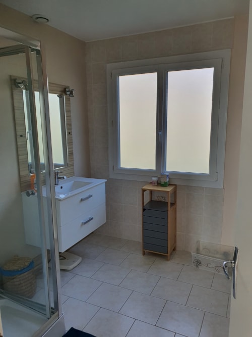 Salle de bain moderne de l'Hôtel Cheverny La Vie Est Belle avec meuble-lavabo blanc, grandes fenêtres, douche et rangements en bois