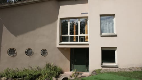 Entrée principale de la Villa Pré d'Oro avec façade beige, hublots décoratifs et porte verte