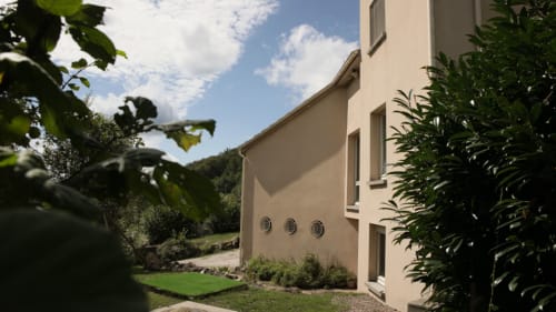 Façade latérale de la Villa Pré d'Oro nichée dans la nature avec vue sur les collines