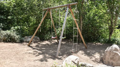 Aire de jeux pour enfants de la Villa Pré d'Oro avec balançoire en bois et cadre naturel