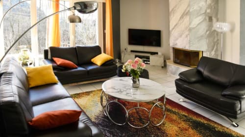 Salon prestige de la Villa Pré d'Oro avec TV, cheminée design et table basse en marbre