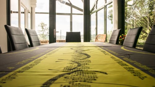 Table à manger de la Villa Pré d'Oro dressée avec nappe verte - vue sur la véranda et le jardin