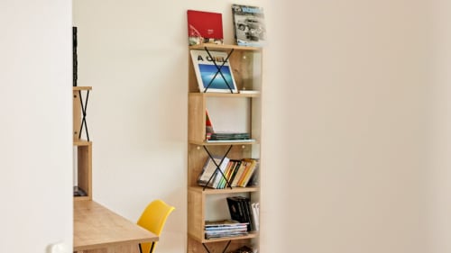 Bibliothèque en bois de la Villa Pré d'Oro avec collection de livres et chaise design jaune