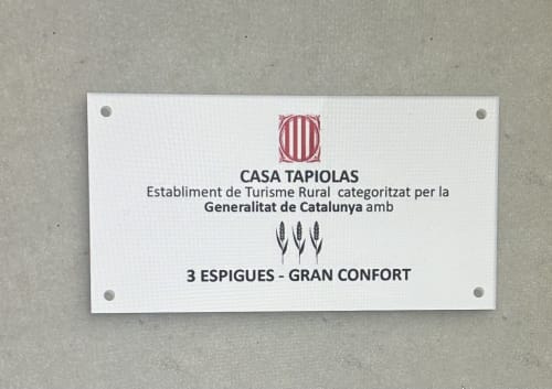 Placa de certificación de turismo rural Casa Tapiolas mostrando calificación 3 espigas gran confort, Molló Girona