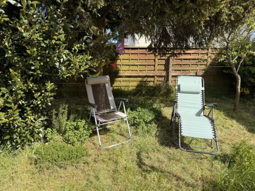 Deux chaises longues dans un jardin ensoleillé du gîte Accolade à Châteaudun, France