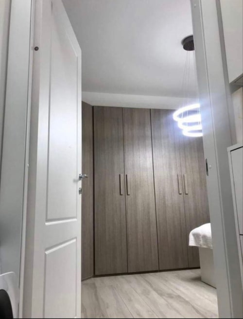 Moderner Schlafzimmereingang in Magnolia Apartments Mailand mit dunklem Holzschrank und hellem Bodenbelag