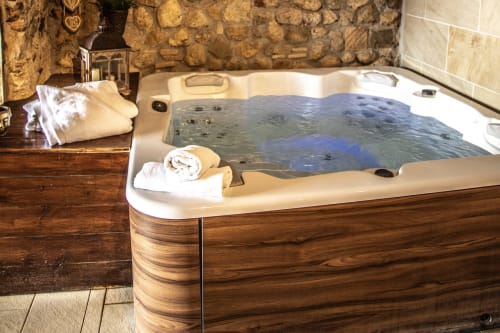 Luxueux bain à remous avec entourage en bois à l'hôtel Masia Can Canyes à Sant Llorenç d'Hortóns, Espagne