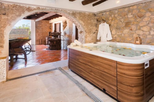 Luxós spa amb banyera d'aigua calenta de fusta a l'hotel Masia Can Canyes de Sant Llorenç d'Hortóns, amb parets de pedra rústica