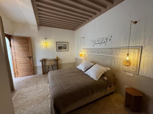 Suite Jamal du Riad Casa Angelo à Marrakech avec lit aux oreillers blancs, tête de lit en zellige traditionnel et