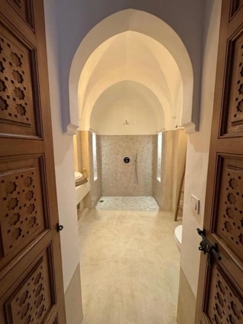 Salle de bains luxueuse de la Suite Jamal au Riad Casa Angelo Marrakech avec plafond voûté, sols en marbre et zone douche