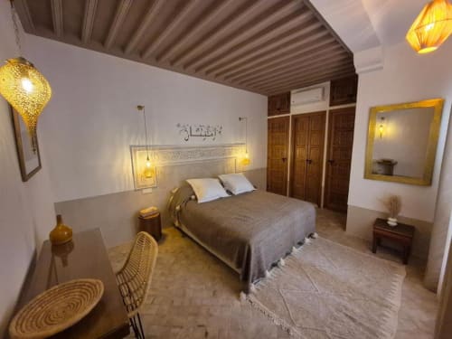Suite Jamal au Riad Casa Angelo à Marrakech avec lit, bureau, éclairage doré et décoration marocaine traditionnelle