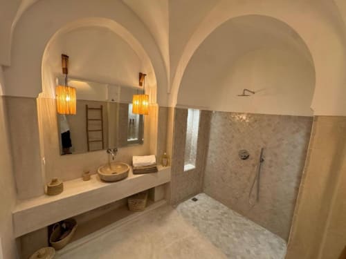 Salle de bains luxueuse de la Suite Jamal au Riad Casa Angelo, Marrakech, avec plafonds voûtés, finitions en marbre et modernité