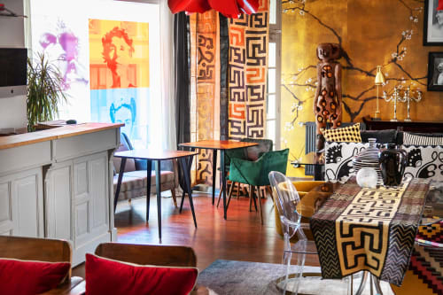 Lounge de l'Alombre B&B à Lectoure avec décor éclectique, motifs géométriques, œuvres d'art colorées et espaces détente vibrants