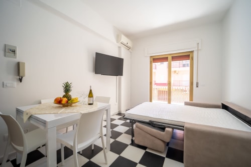 Moderno monolocale a Marina di Strongoli con letto, tavolo da pranzo, TV e accesso a balcone con vista mare