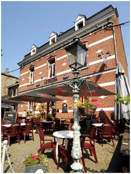 Hôtel Le Moulin Des Ramiers à Crupet : façade en brique, auvent rouge, terrasse extérieure et lampadaire décoratif