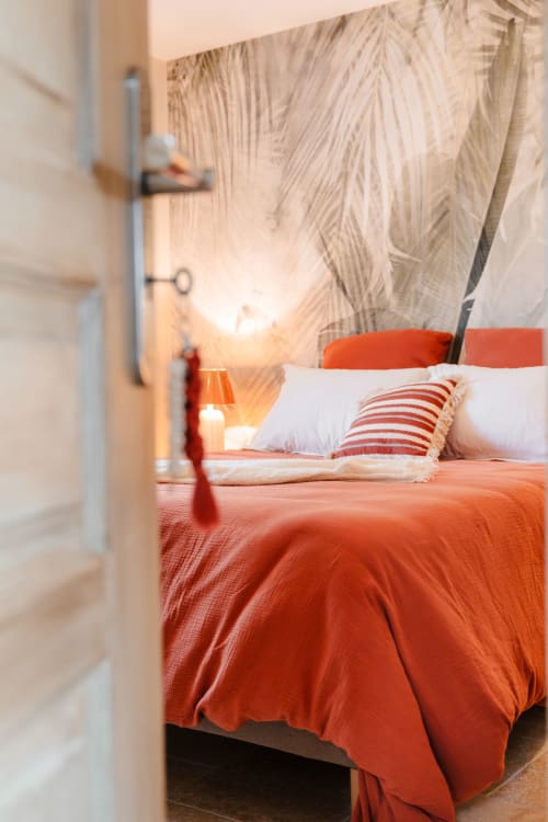 Ground-floor bedroom at Le Logis — 160 cm bed, botanical wallpaper and soft lighting for a peaceful stay near Blois.
