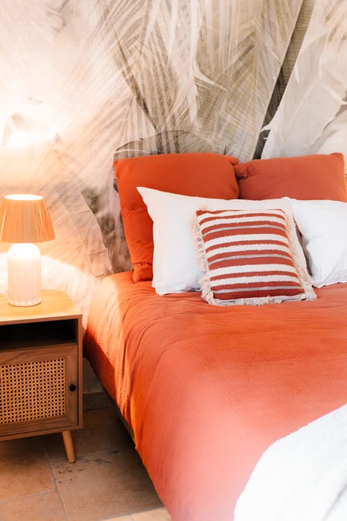 First ground-floor bedroom at Le Logis — double bed, natural decor and discreetly placed TV, perfect for a comfortable stay near Blois.
