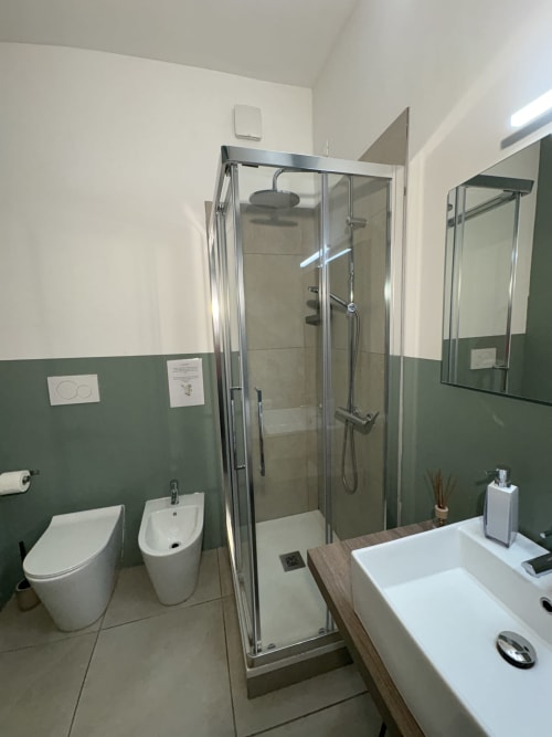 Bagno moderno nella camera Tosca di Le Arche hotel a Verona, con doccia walk-in, doppio lavabo, wc, specchio e