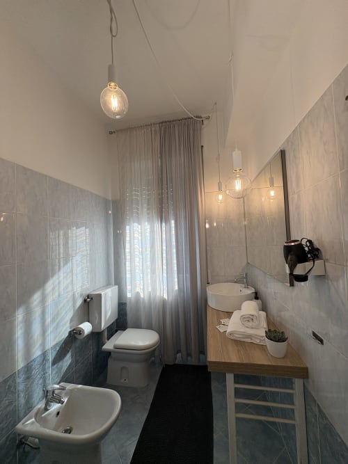 Bagno moderno nella camera Traviata dell'Hotel Le Arche di Verona, con eleganti lampade a sospensione e arredi contemporanei