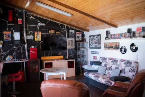 Sala de estar en apartamento de Mérida con área de entretenimiento, asientos de cuero y decoraciones murales con fotos