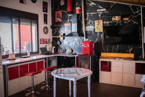 Apartamento moderno en Mérida con decoración roja y negra, cocina, escritorio de trabajo y arte mural temático vintage Hollywood.
