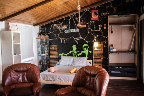 Apartamento moderno en Mérida con arte pop neón, sillones de cuero marrón, pared de acento negro con mapa de la Ruta 66 y techo de madera