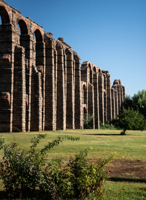 Ruinas del acueducto romano antiguo de Mérida con múltiples arcos y columnas de piedra bajo cielo despejado