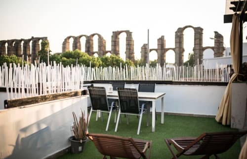 Terraza en azotea con vistas al antiguo acueducto romano de Mérida, con mobiliario y césped artificial