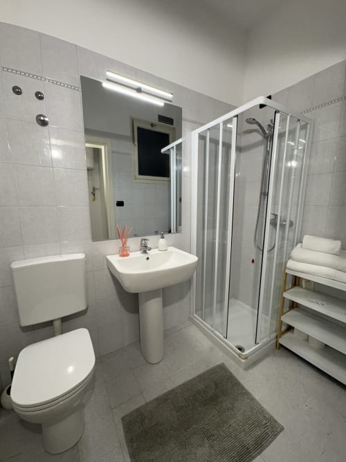 Bagno moderno nell'appartamento Catullo 12 de Le Arche, Verona con doccia, lavabo, wc, portasciugamani e specchio