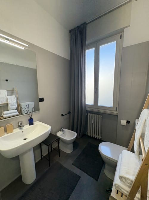 Bagno moderno dell'hotel Le Arche a Verona con lavandino, bidet, wc e ampia finestra